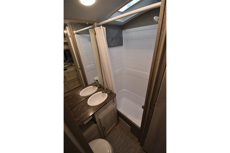 RV rental bathroom with modern double sinks, a clean shower, and toilet. Ideal for comfortable travel. — photo 18