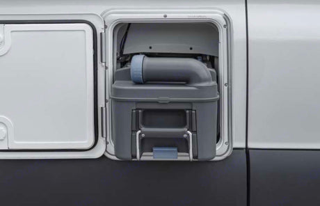 RV rental: Exterior access panel open, revealing the gray toilet waste cassette. Essential for sanitation & easy disposal during travel.
