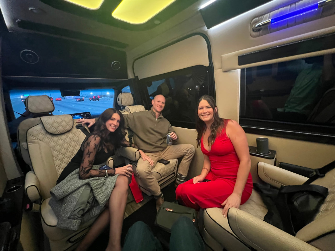 Smiling friends enjoying a plush RV rental interior. The luxury van offers comfort and ambient lighting for their night journey. — photo 15
