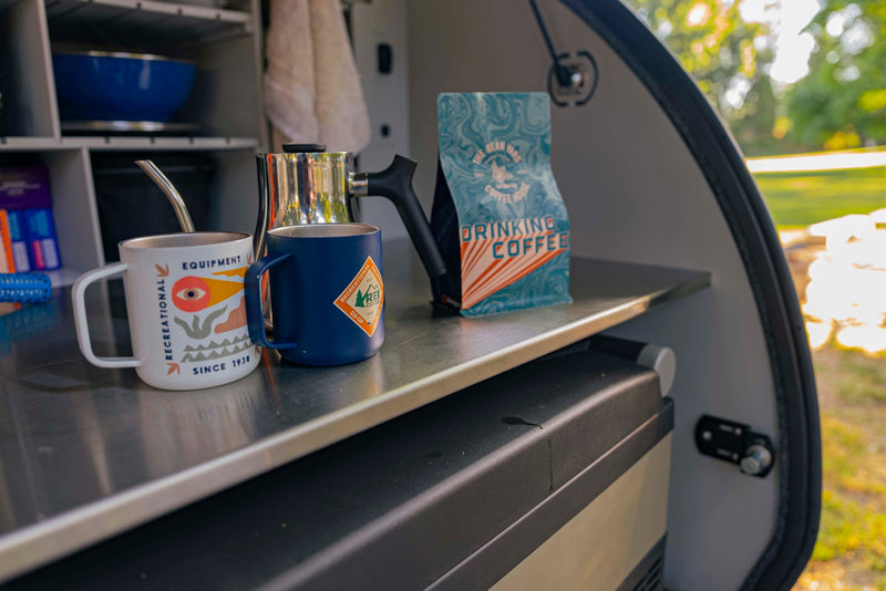  complete with mugs and a pour-over setup.|A close-up of coffee supplies inside an rv rental: a white mug — photo 4