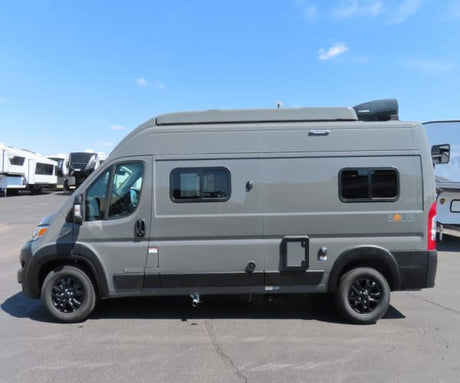 Side view of a modern grey Winnebago Solis campervan for RV rental, parked outdoors. Perfect for your next adventure.