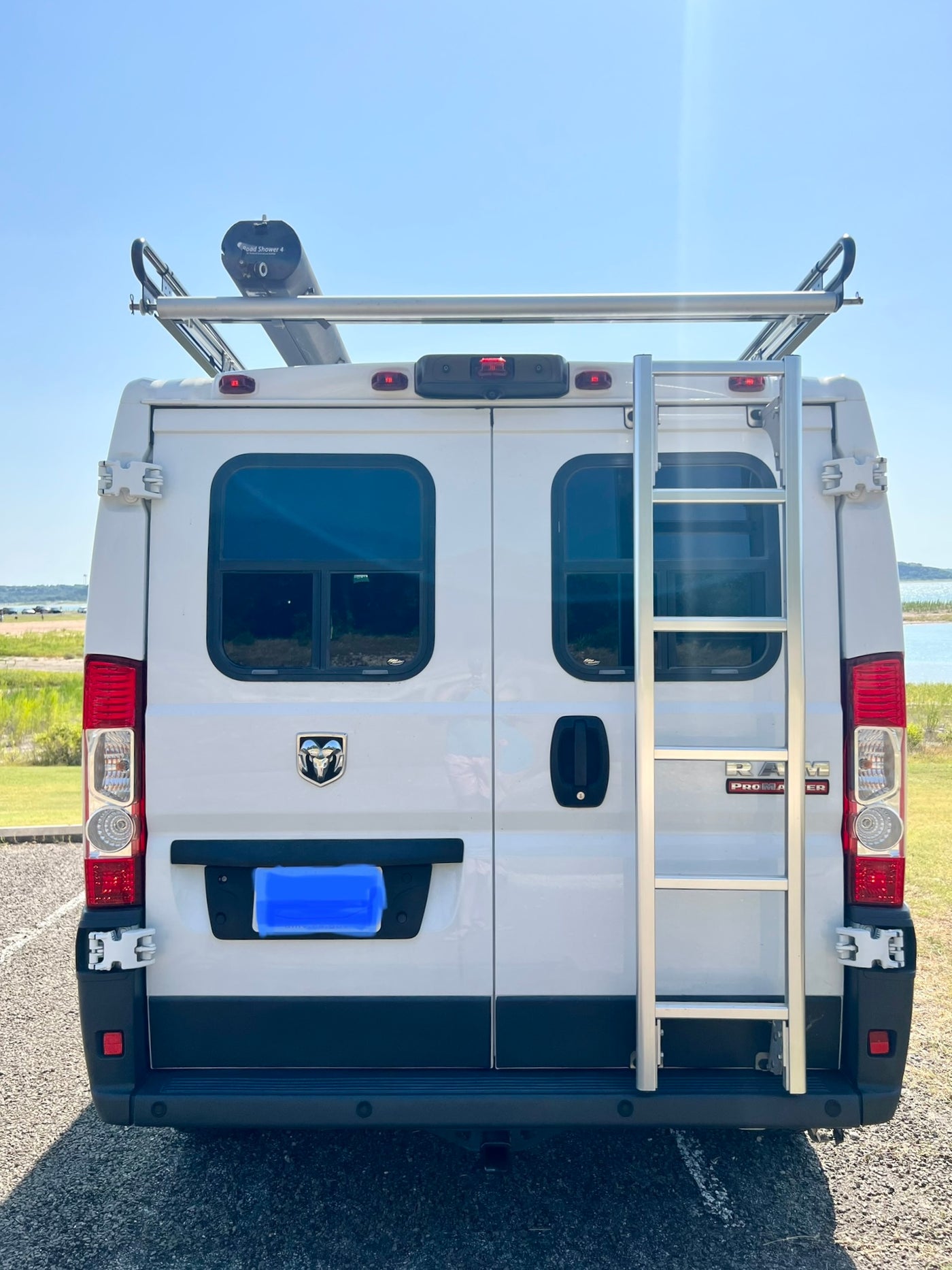 RV rental: White Ram ProMaster camper van with roof rack, ladder, and Road Shower 4 for van life adventures. — photo 18
