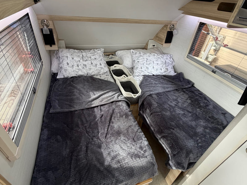  and a compact kitchen on the right with a fridge.|Inside an RV rental: two comfy beds with grey blankets — photo 10