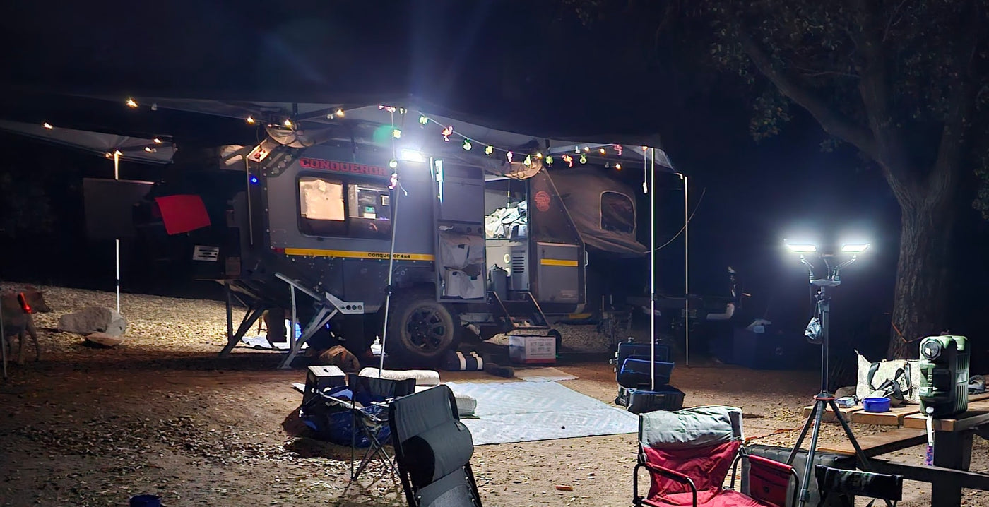 Nighttime off-road RV rental campsite: a well-lit Conqueror caravan with string lights and a cozy outdoor setup for adventure. — photo 17