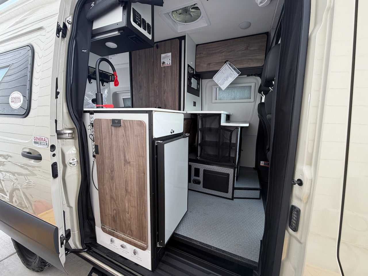 Inside this rv rental camper van: compact kitchen with sink, fridge, and smart storage, perfect for road trips. — photo 6