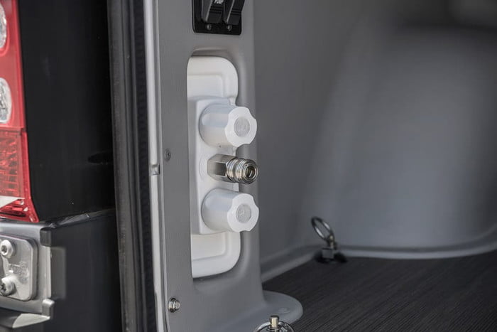  enjoying a scenic lake view with a mat laid out.|An RV rental's modern kitchen counter & sink. Through the screen — photo 10