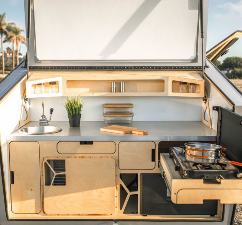  is parked among snow-capped mountains. A bed is visible inside.|Cozy bed inside an RV rental. Wake up to panoramic mountain and desert views through the unique window — photo 4