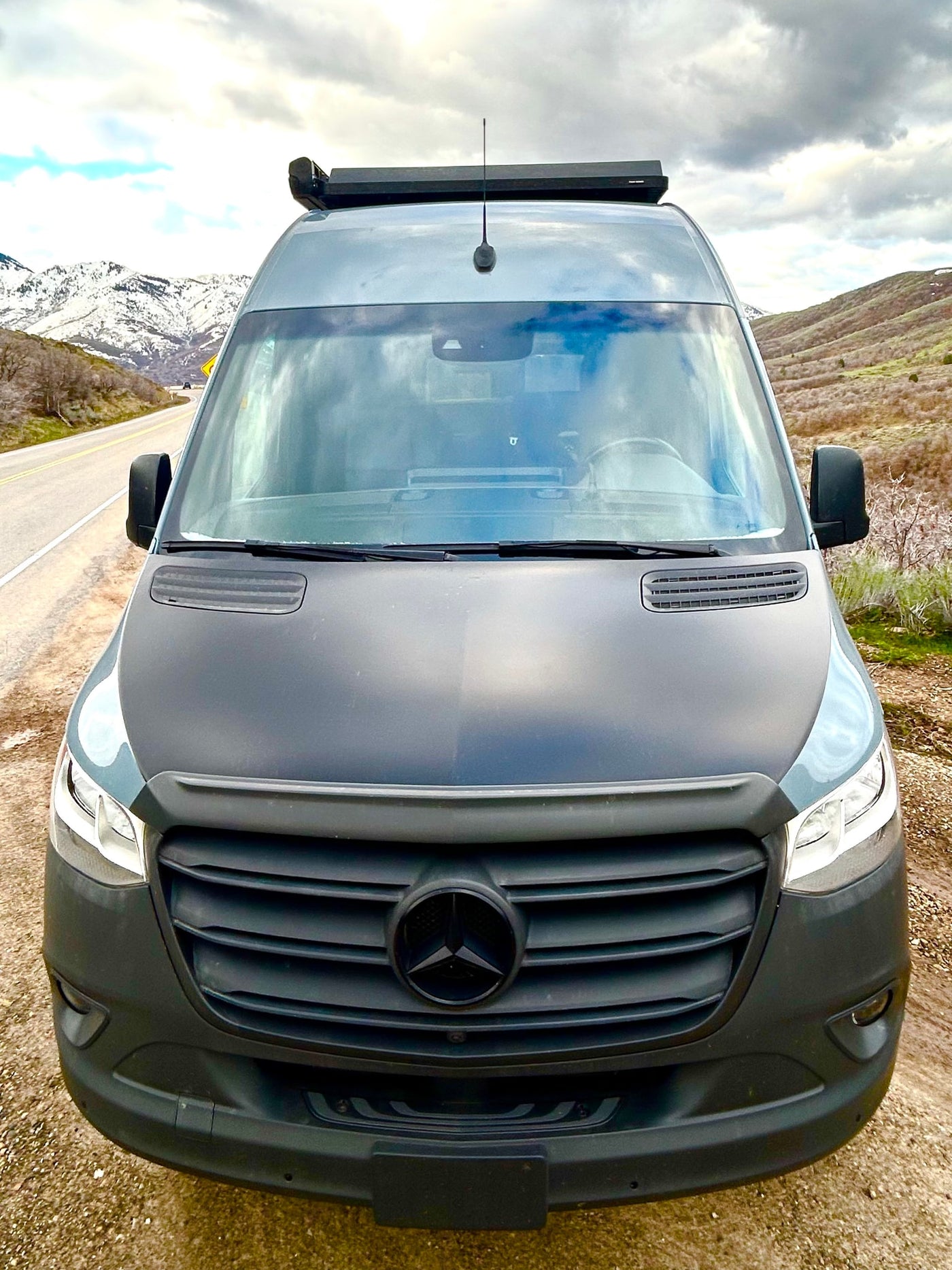 Front view of a dark grey Mercedes-Benz Sprinter rv rental camper van, ready for mountain travel & adventure. — photo 8