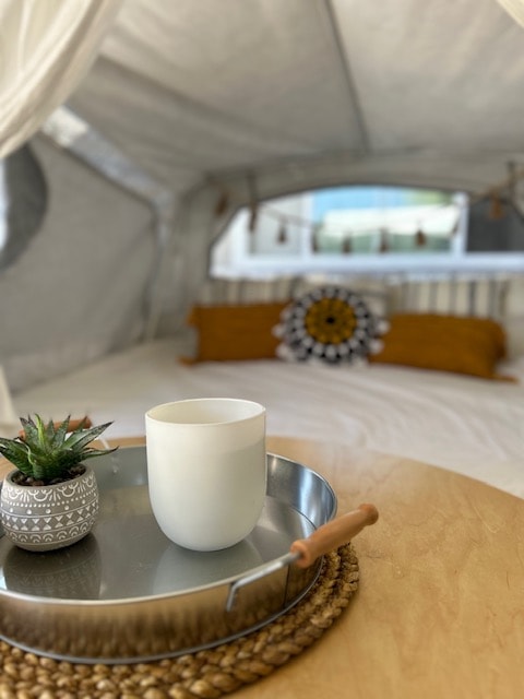 Cozy RV rental interior: a comfy bed, tray with mug & succulent, set in a bright pop-up camper. Your next adventure! — photo 6