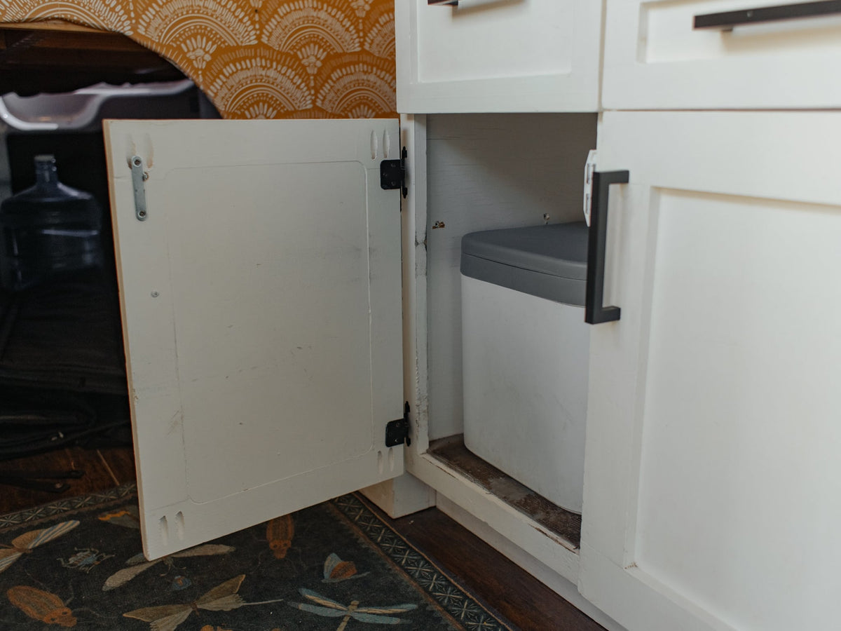  and a kettle.|Cozy RV rental van interior with a bed in the rear — photo 8