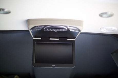 Enhance your journey in an RV rental with this convenient flip-down ceiling monitor and integrated overhead lighting.