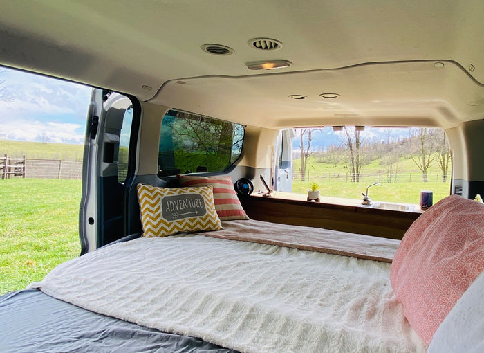  & inviting pillows for your travel adventures.|Inside this RV rental: A camper van's custom rear kitchen with sink