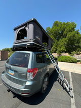 Grey Subaru Forester with an open TentBox rooftop tent and extended ladder. Great compact **rv rental** option.