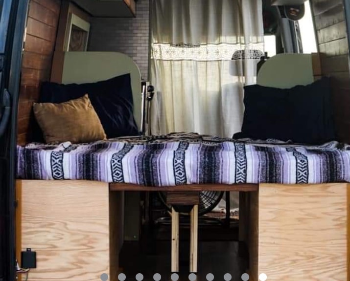  and an 'ECO' cooler.|Compact RV rental interior shows a cozy bed with blanket — photo 8