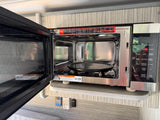 This open Galanz 900-watt microwave and air fryer oven is ready for use in an RV rental, offering various cooking modes.