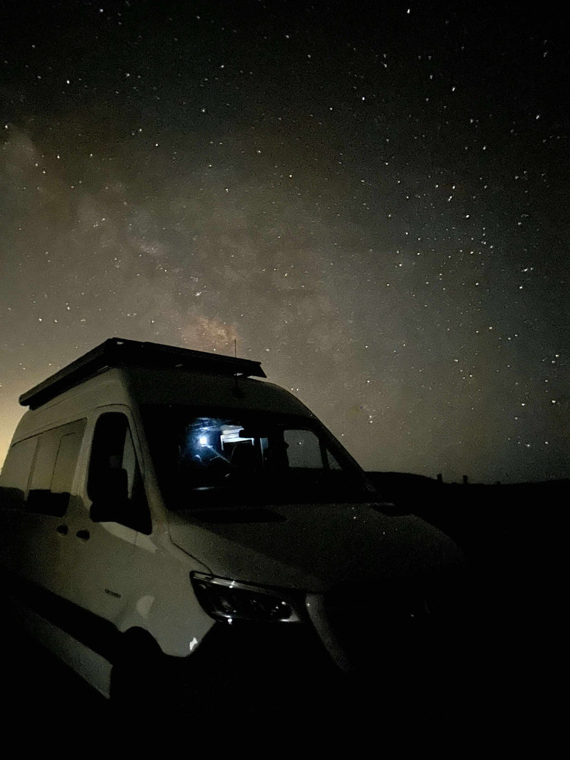 An RV rental van sits under a vivid Milky Way night sky — photo 1
