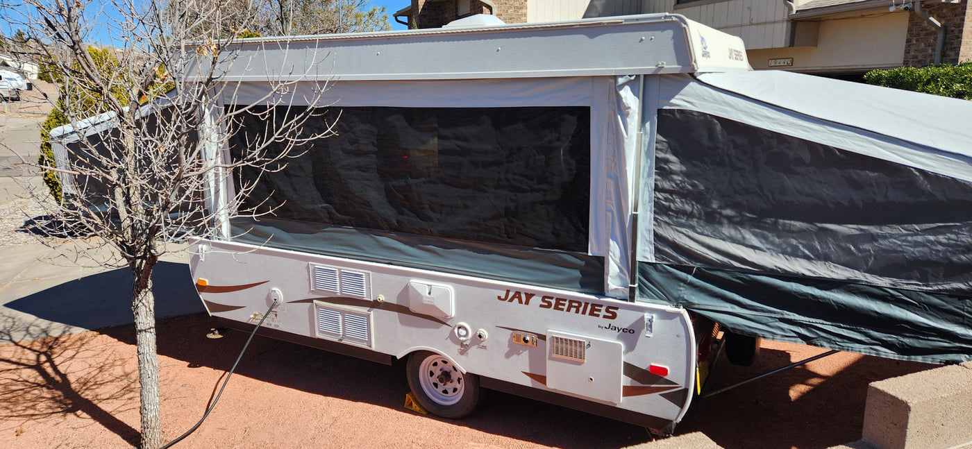 A grey and white Jayco pop-up camper, extended and set up outdoors, perfect for an rv rental getaway. — photo 9