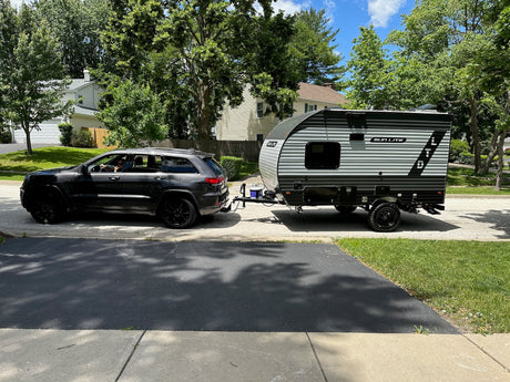  and travel trailer with lighted awning among trees.|This **rv rental** travel trailer is parked
