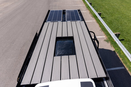 Overhead view of an RV rental roof with solar panels, a walk-on deck, and vent. Ideal for off-grid power.