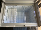 RV rental essential: Open portable fridge/freezer with internal baskets, ideal for travel cooler needs.