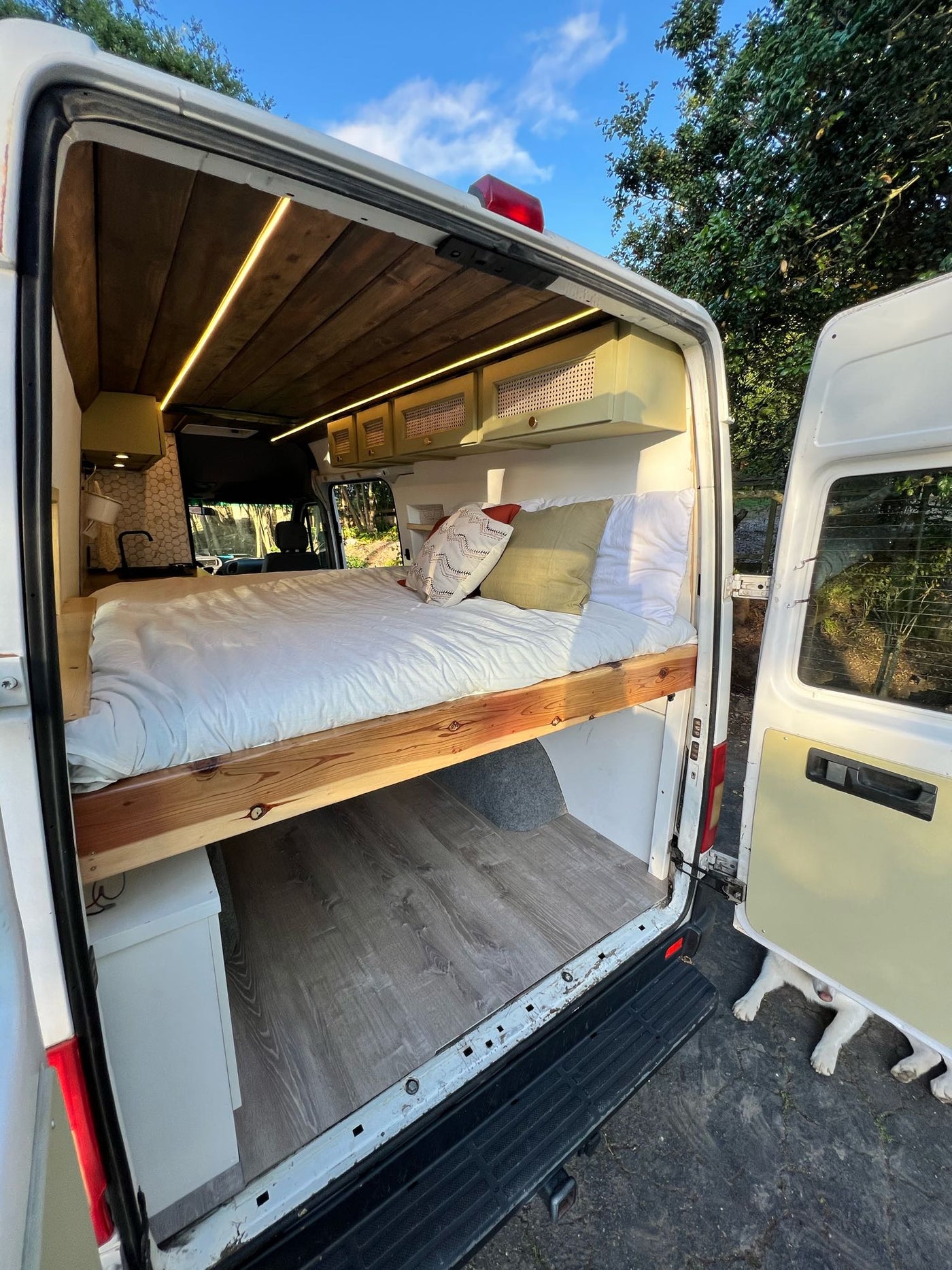  and a practical pull-out table. Ideal for van life travel.|This RV rental showcases a cozy interior with a bed — photo 16