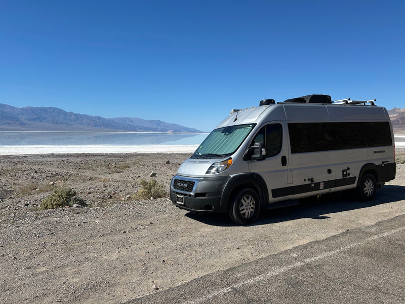  sunshade on windshield.|Silver RV rental camper van parked at Death Valley's reflective salt flats — photo 6