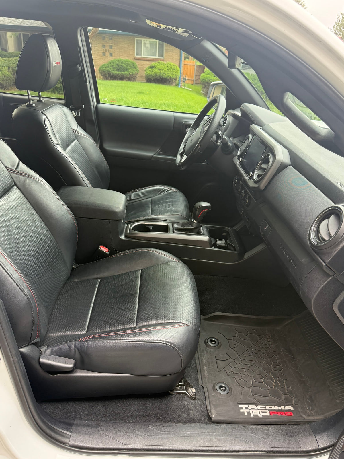 Detailed Toyota Tacoma TRD Pro interior features black leather seats with red stitching & a modern dashboard. Ideal for RV rental trips. — photo 10