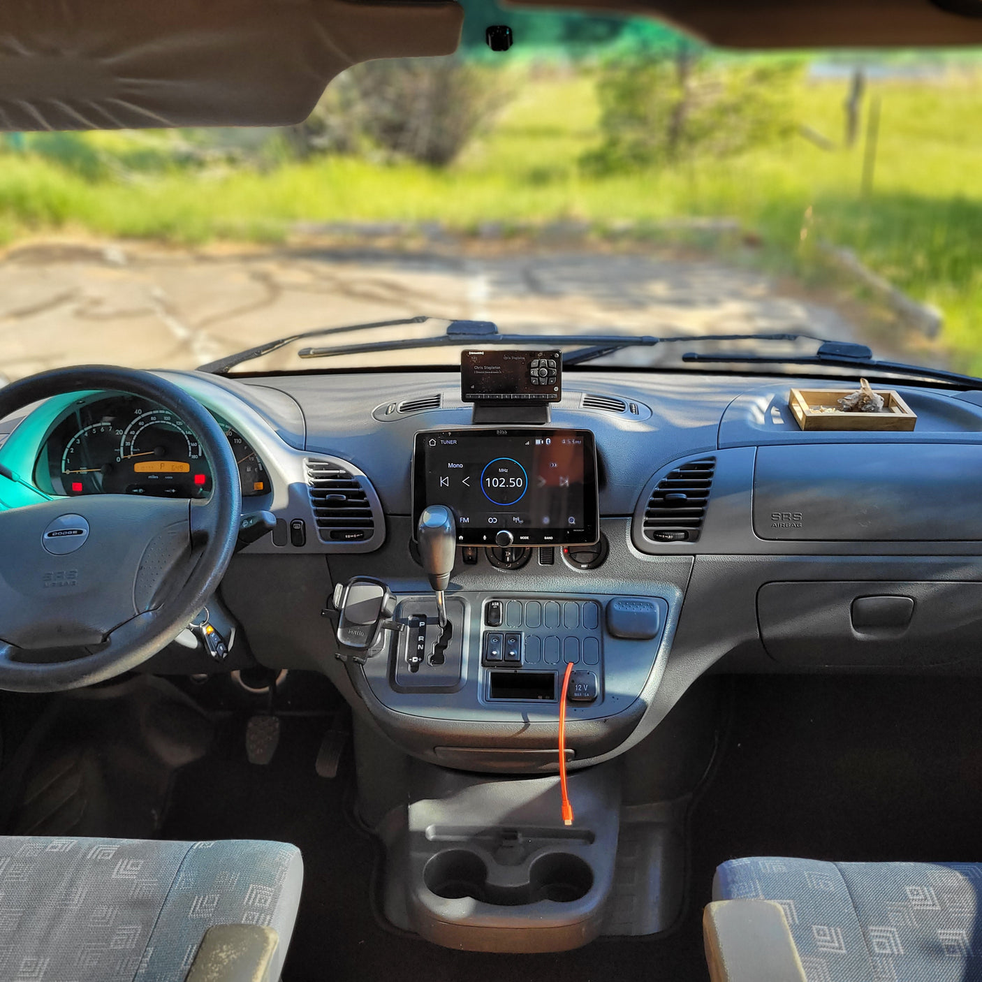 Dashboard of a Dodge RV rental, showing infotainment, SiriusXM radio, and cup holders, ready for your next road trip adventure.