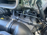 RV rental engine bay view: hoses, air intake, and engine components for essential vehicle maintenance checks.
