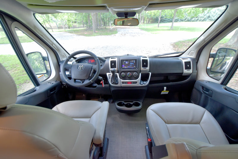 Spacious RV rental cockpit: light-colored seats, a detailed dashboard, and a clear view of the road ahead. — photo 5