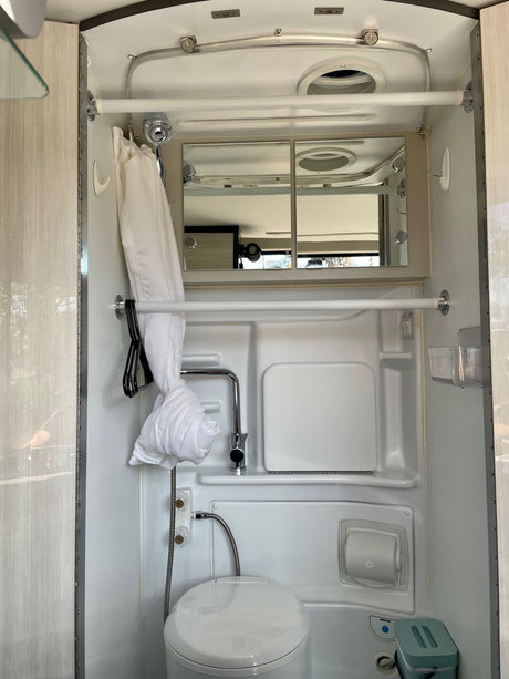 **RV rental** compact wet bath with white toilet, sink, and shower, designed for space efficiency.