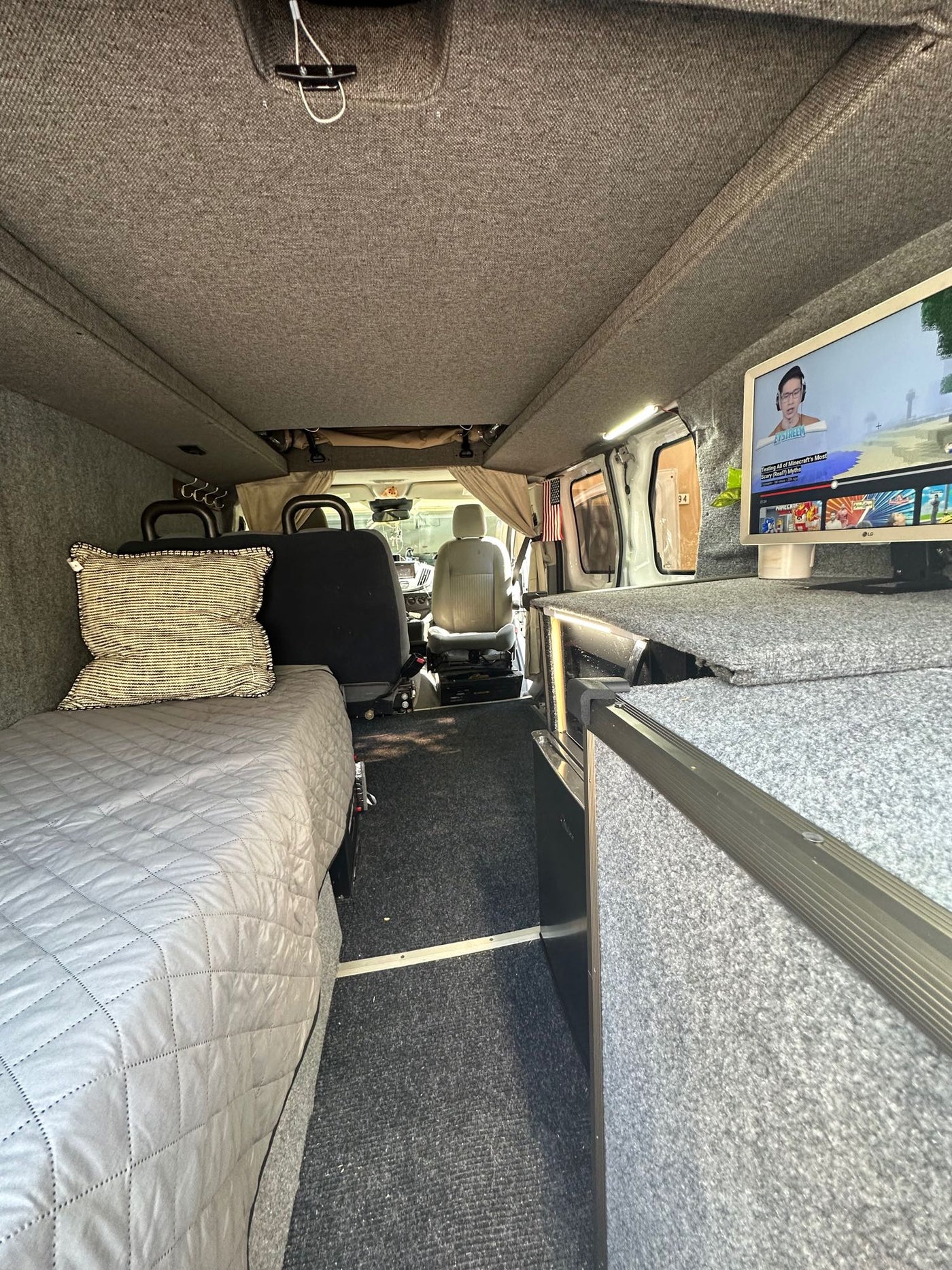  parked for camping.|White Ford Transit pop-top campervan (RV rental) at a serene campsite under large trees — photo 6
