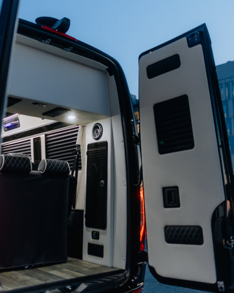 Luxury RV rental interior: Custom van with plush seating, wood flooring, and modern lighting. Perfect for comfortable travel.
