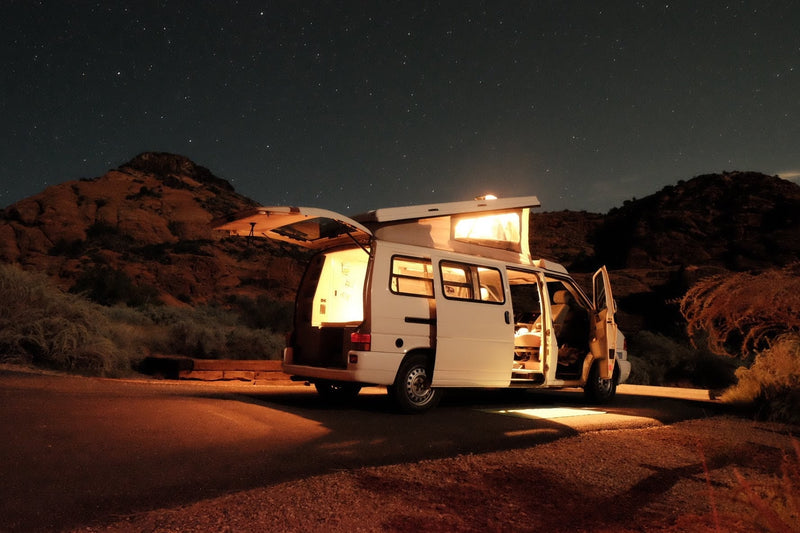 Starry night adventure! An illuminated white RV rental camper van parked in a mountainous desert under a sky full of stars. — photo 2