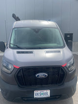 Gray Ford Transit van with Missouri plate VK9 H8L, potentially an RV rental, parked. Roof rack equipment visible.