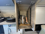 Compact & organized RV rental kitchen: percolator, pans, sink, and smart storage for travel convenience.