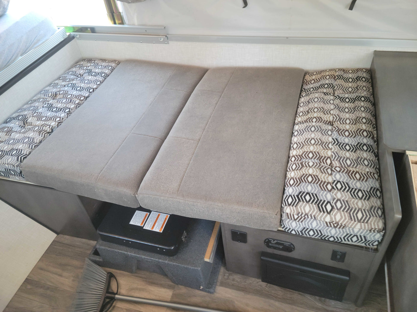 Experience comfort in this RV rental! Features a dinette with cushions, under-seat cooktop, and electrical panel.