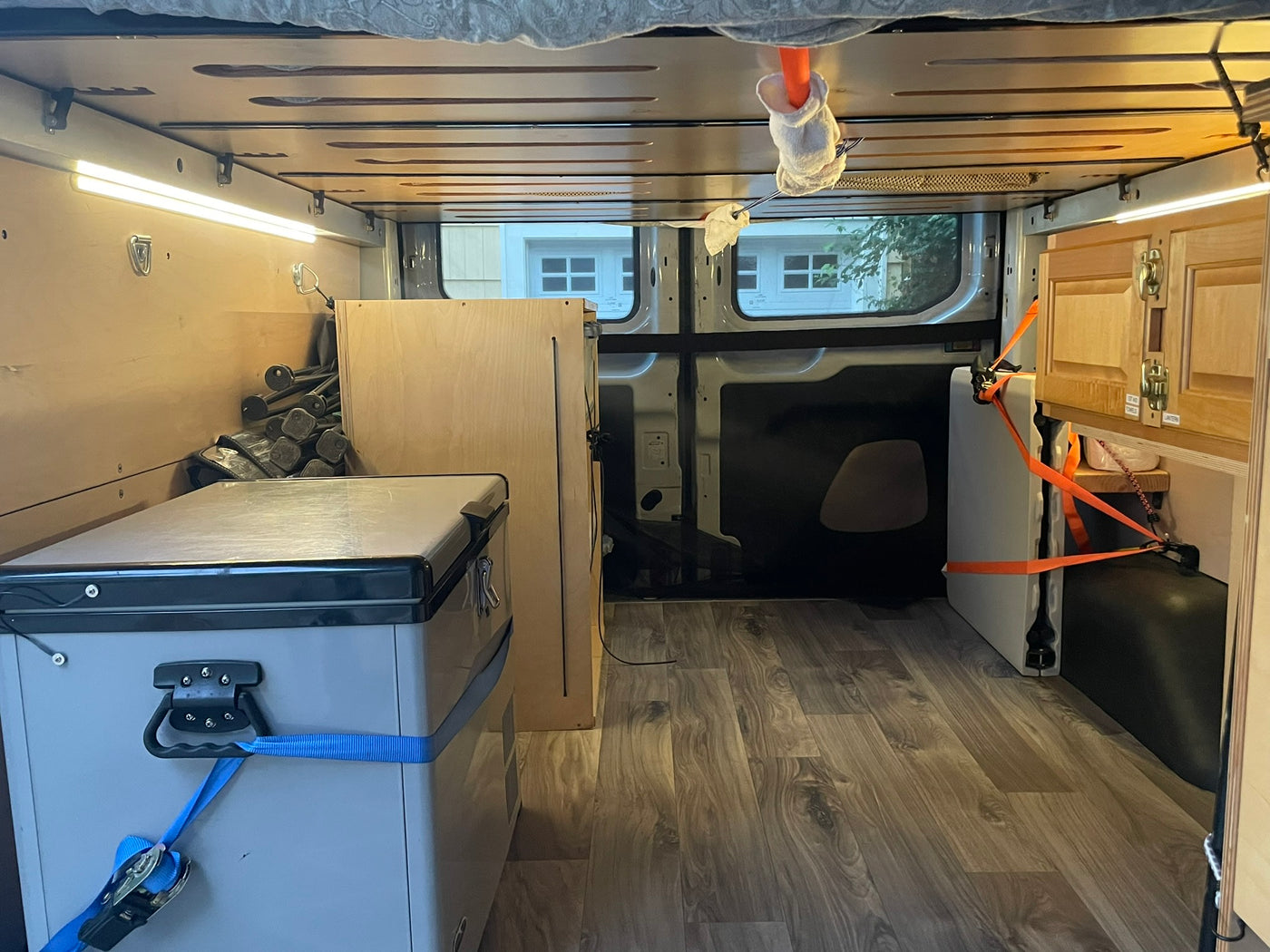 Cozy RV rental interior with organized storage, bright LED lighting, and a portable fridge. Ideal for mobile living. — photo 12