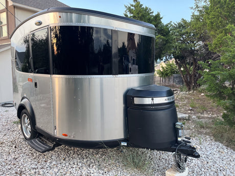 Sleek silver Airstream Basecamp travel trailer, an RV rental perfect for outdoor adventures.
