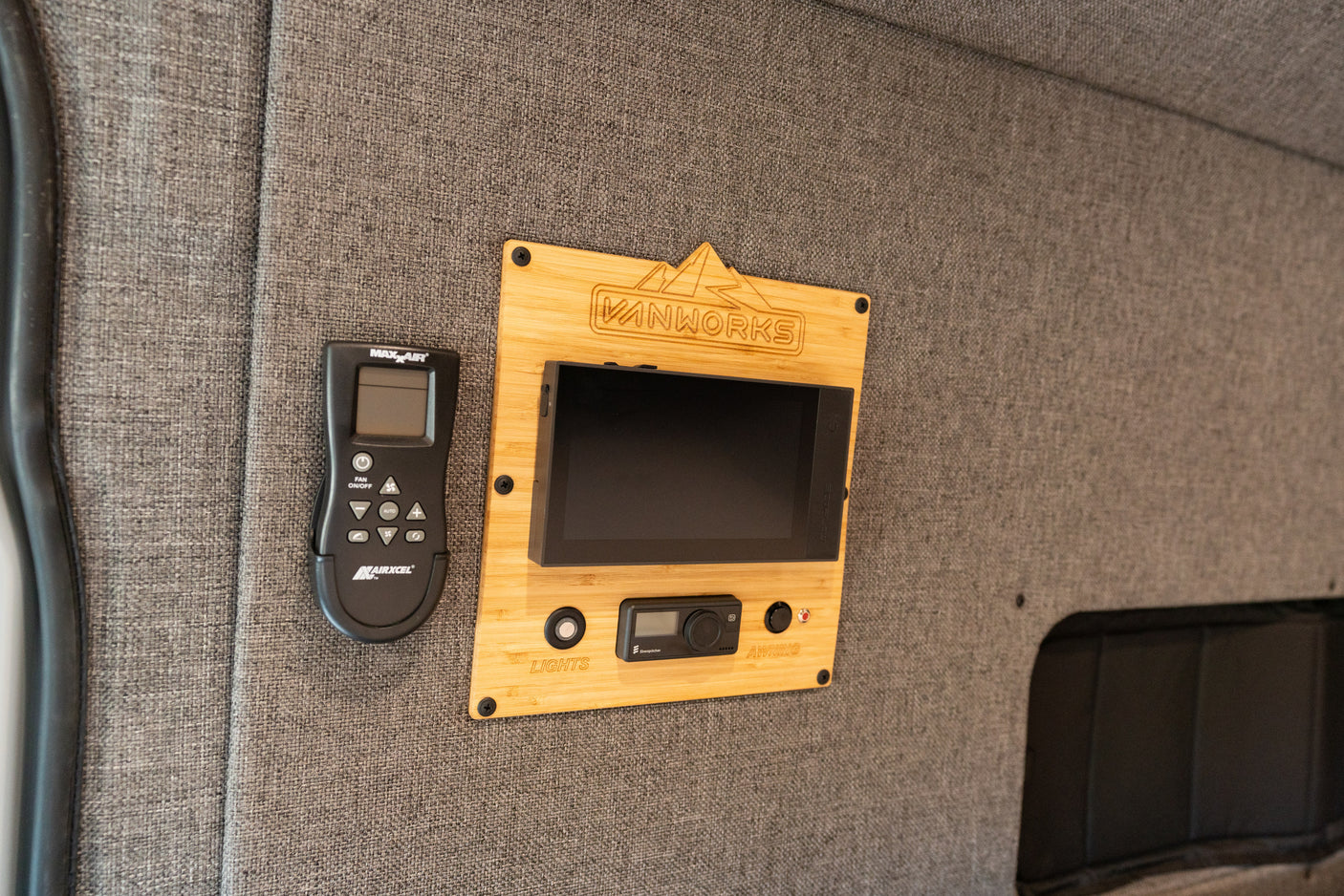 rv rental van's organized control panel: MaxxAir fan remote, Vanworks bamboo panel with system screen, Eberspächer, lights & awning.