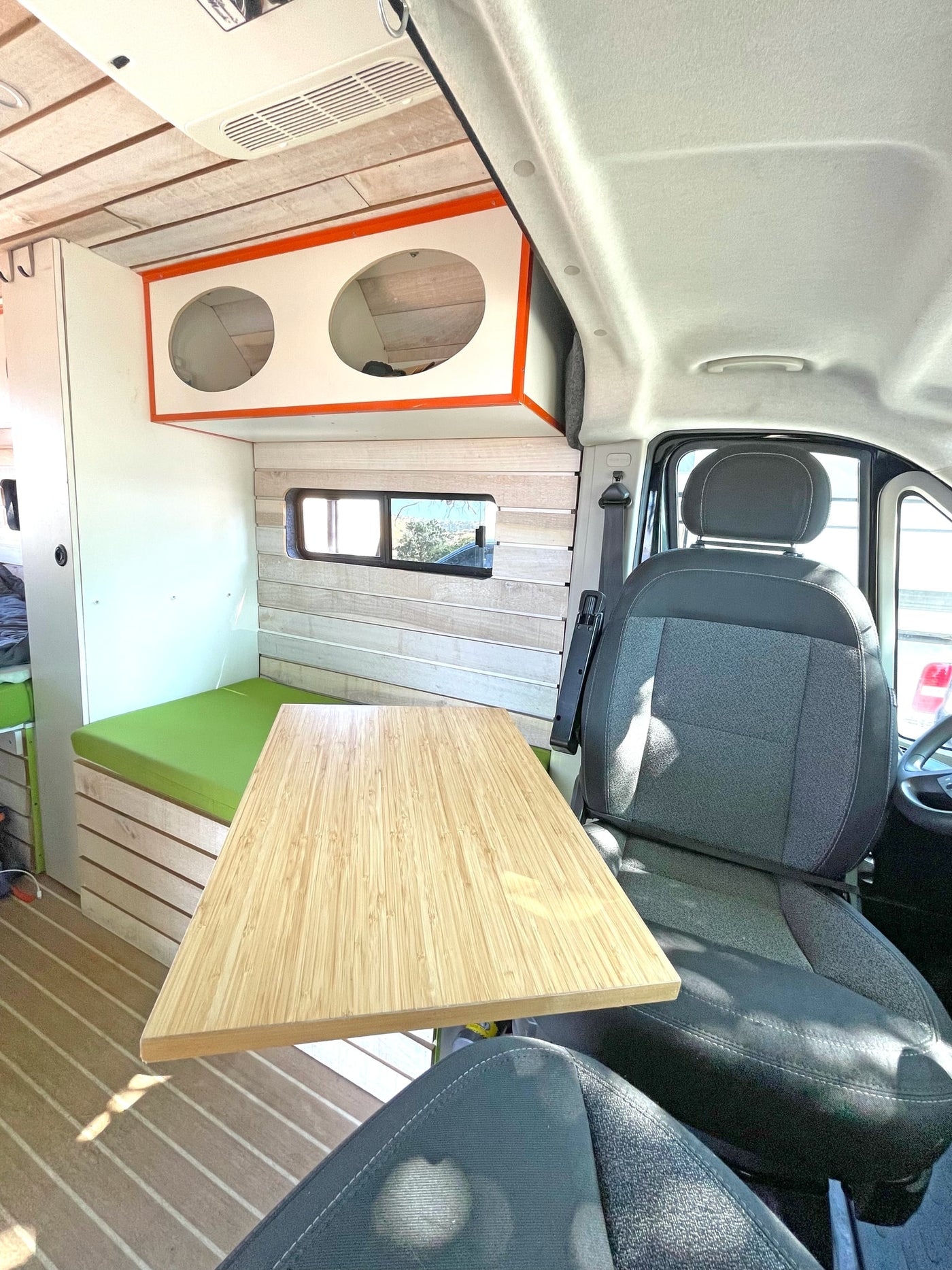  overlooking a scenic landscape.|Vibrant green benches and wood-plank floor inside an RV rental — photo 10