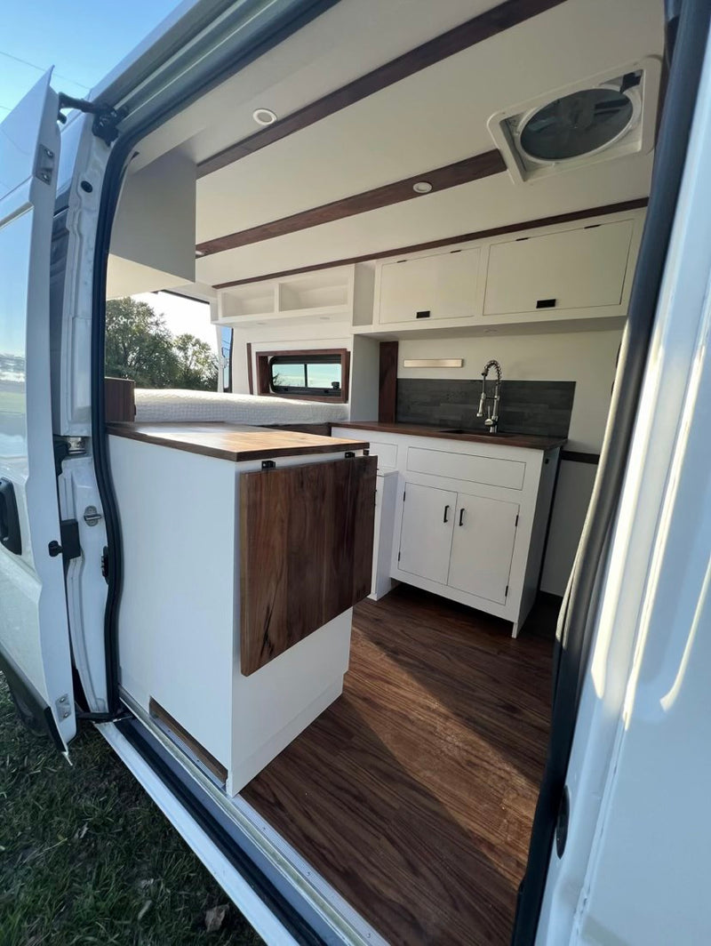  with bed above and power system.|Explore this clean RV rental interior featuring a full kitchen with sink — photo 5