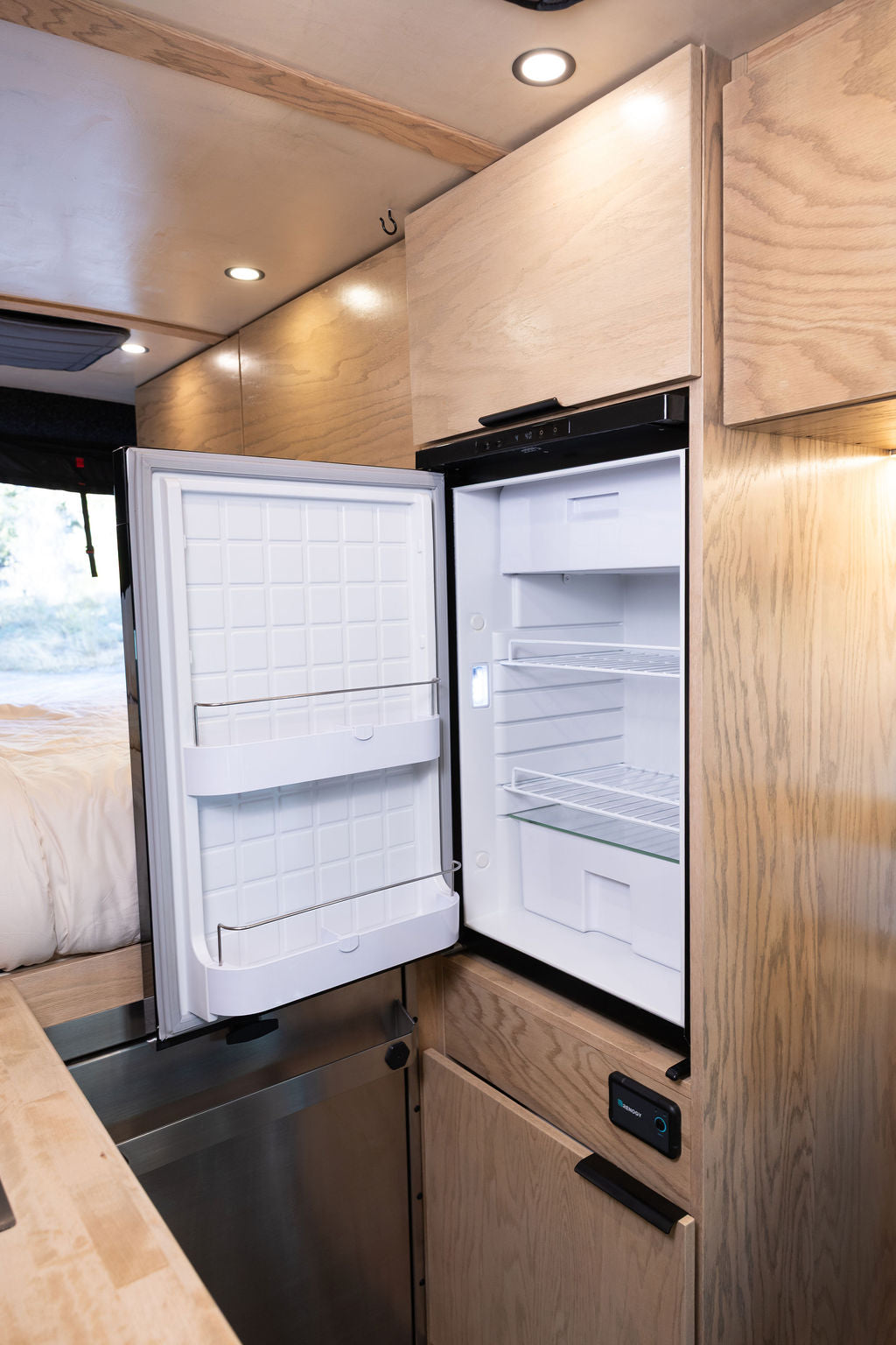  and custom wooden cabinetry. Perfect for vanlife adventures.|Compact RV rental kitchen features light wood countertops — photo 7