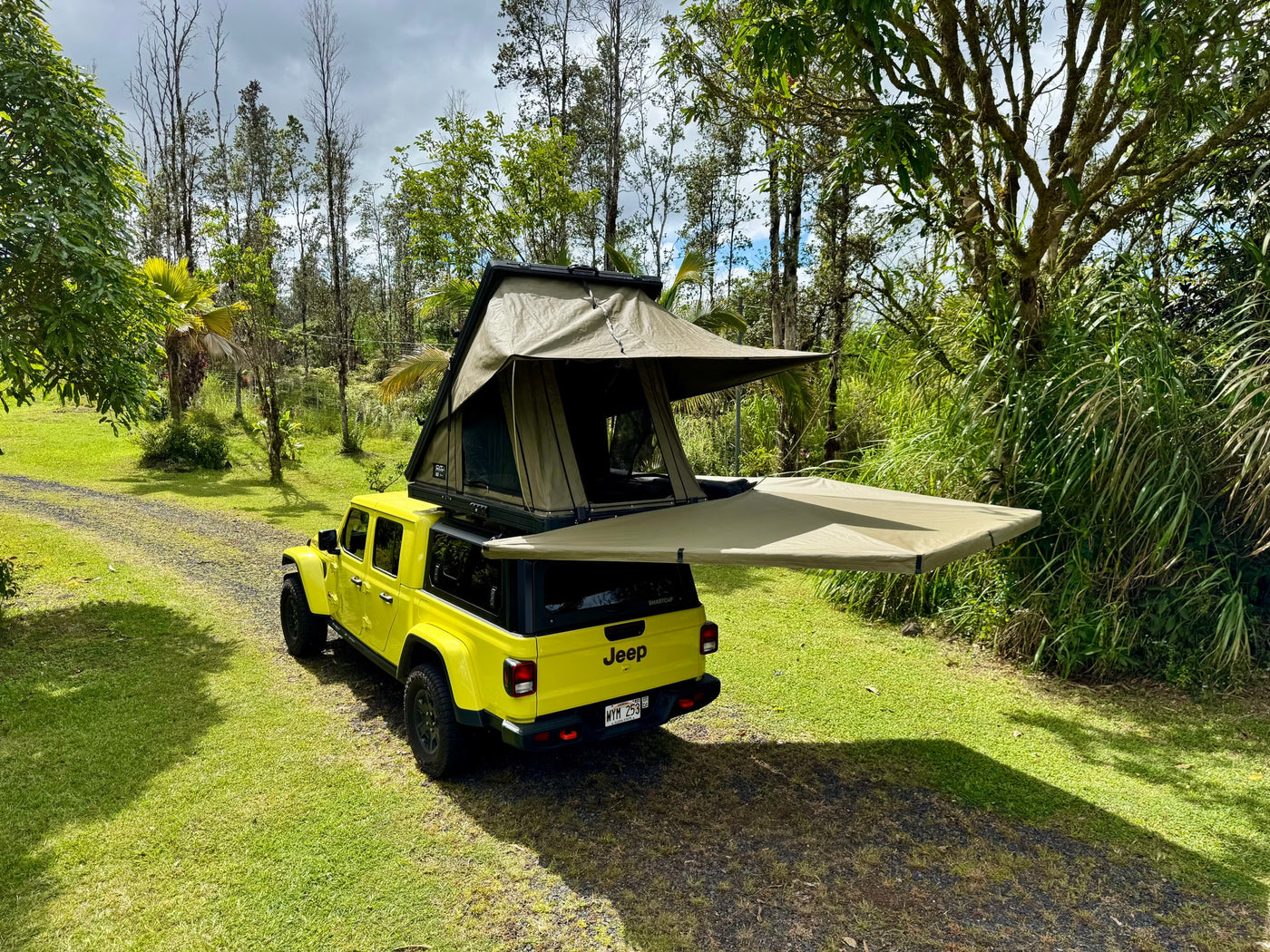 A yellow Jeep Gladiator with a rooftop tent and extended awning, parked on grass for your RV rental camping adventure. — photo 4