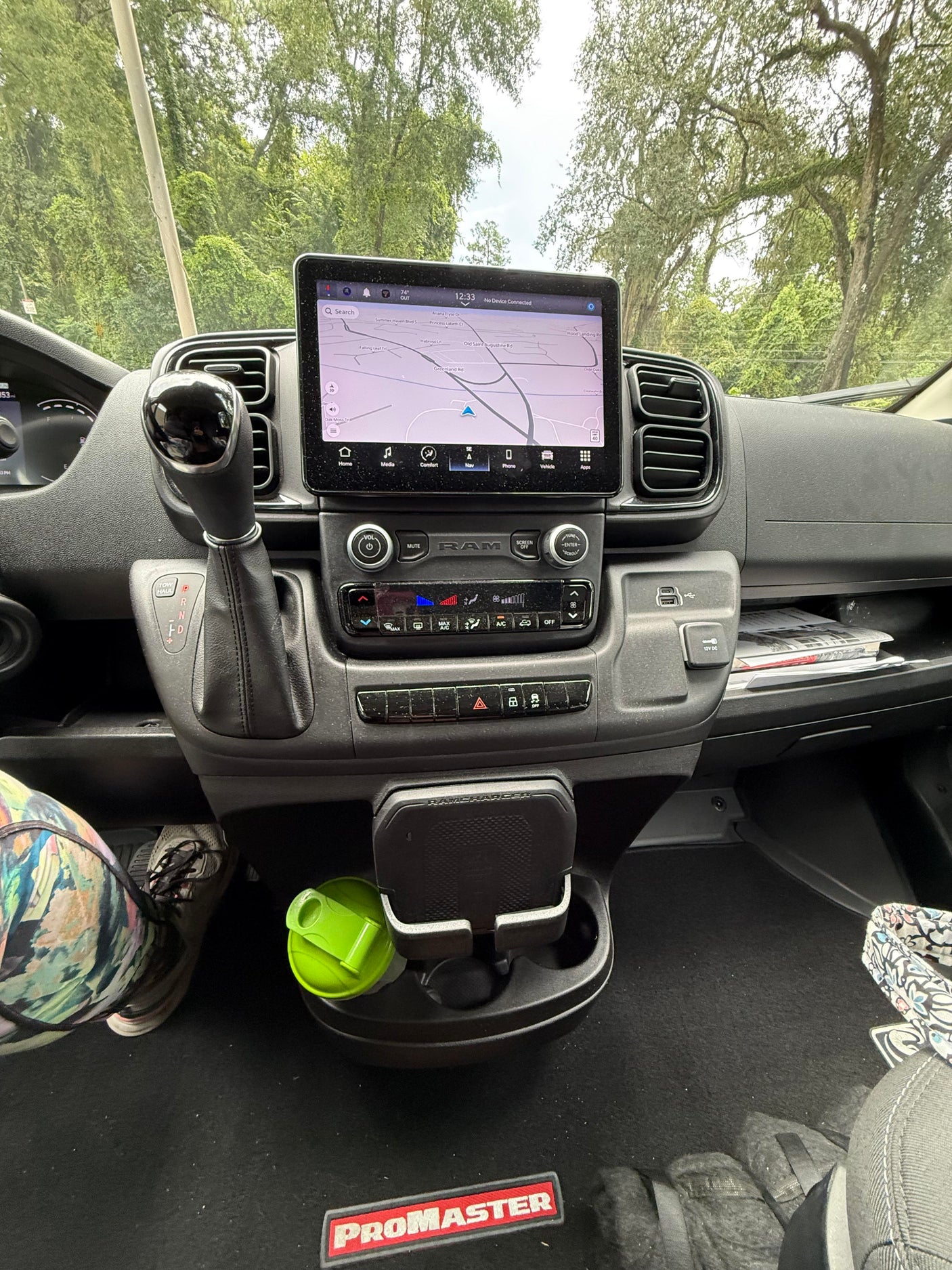Dashboard view of an RV rental: Ram ProMaster interior with touchscreen navigation, gear shift, and climate control panel.