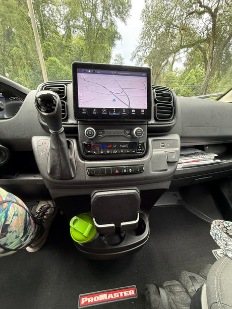 Dashboard view of an RV rental: Ram ProMaster interior with touchscreen navigation, gear shift, and climate control panel.