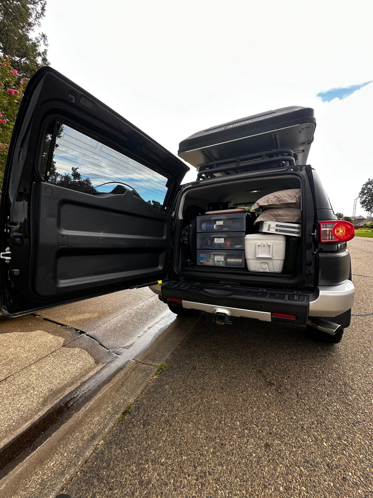Black SUV with open trunk, organized camping gear in drawers & iKamper rooftop tent. Great for overlanding or an rv rental trip. — photo 12