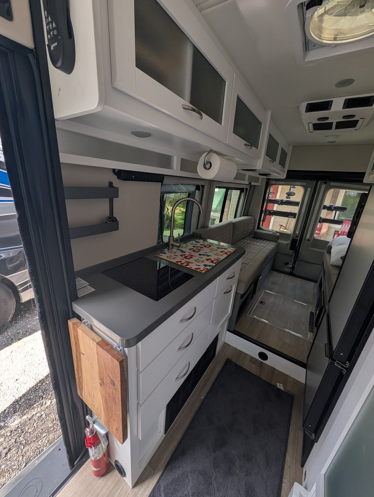  another RV reflects in the screened door.|Interior view of an RV rental van's front cabin — photo 4