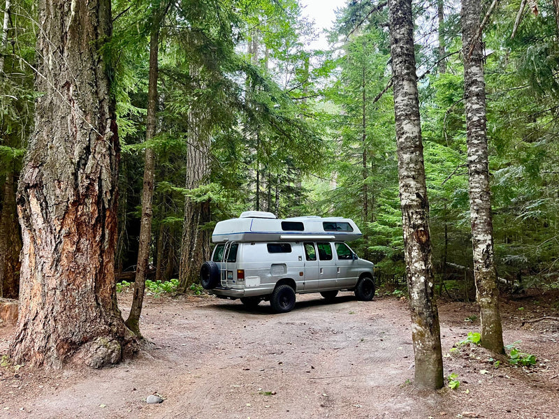  and tech controls for a comfortable adventure.|View of a modern RV rental camper van interior. Features a kitchen with sink/stove — photo 9