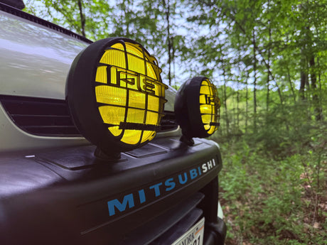 This rugged Mitsubishi SUV with yellow fog lights is ready for forest trails, ideal for your RV rental adventure.
